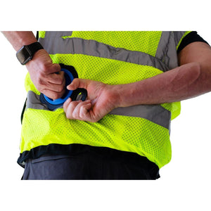 Person wearing a high visibility safety vest attaching a blue and black circular clip to the waist