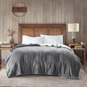 Woolrich grey heated blanket on a bed with wooden headboard