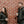 Man and woman wearing black ActionHeat puffer jackets standing against a brick wall holding coffee cups
