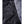 Water droplets on black quilted fabric next to grey textured material on a Heat Experience garment
