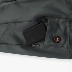 Mobile Warming battery pack connected inside a grey garment pocket with a circular power button
