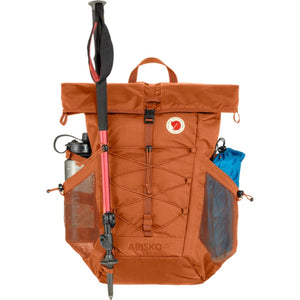 Fjallraven Abisko 25 backpack in terracotta with trekking pole and water bottle in side mesh pockets