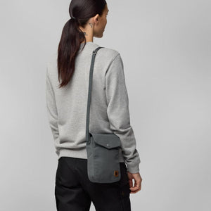 Person wearing a grey FjallRaven shoulder bag over a grey sweatshirt