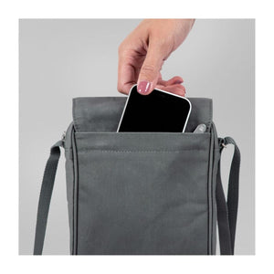 Hand placing a smartphone into the back pocket of a grey FjallRaven shoulder bag