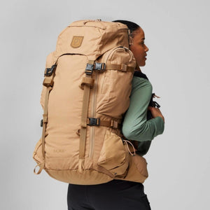 Person wearing a tan FjallRaven Kajka 55 trekking backpack