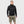 Man wearing a black FjallRaven hooded fleece jacket and olive green cargo shorts