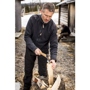Man wearing a black FjallRaven fleece jacket splitting wood with an axe