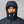 Person wearing a navy blue hooded puffer jacket zipped up to the chin