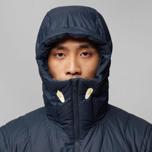Person wearing a navy blue hooded puffer jacket zipped up to the chin