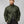 Man wearing a dark green FjallRaven quilted jacket with a high collar and logo patch