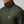 Person wearing a dark green FjallRaven quilted jacket with a high collar and brand logo patch