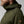 Man wearing olive green FjallRaven hooded fleece jacket with leather zipper pull and logo patch