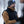 Man wearing a FjallRaven black vest and brown base layer with a grey beanie in a snowy forest