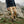 Person hiking in FjallRaven beige cargo trousers and dark jacket on a rocky mountain trail