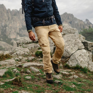 Person wearing FjallRaven beige cargo trousers hiking on a rocky mountain trail