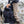 Person wearing FjallRaven trousers opening a black hiking backpack outdoors