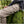 Person wearing beige FjallRaven cargo trousers with G-1000 branding sitting on a mossy rock