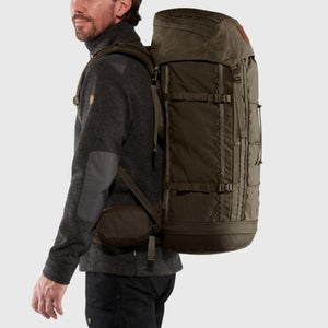 Person wearing a dark green FjallRaven backpack from the side