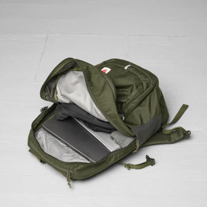 Open FjallRaven green backpack showing internal laptop sleeve and packed items