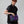 Person wearing a black fleece vest and carrying a purple Fjallraven shoulder bag