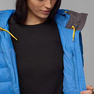 Close up of a person wearing a blue FjallRaven hooded jacket over a black shirt