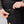 Hand placing a smartphone into the side pocket of black FjallRaven trousers