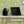 Black Vornado personal desk fan next to a laptop on a white desk