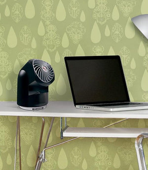 Black Vornado personal desk fan next to a laptop on a white desk