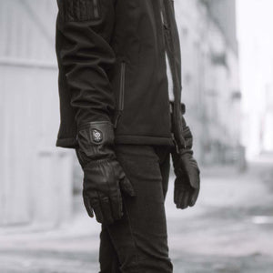 Person wearing black FNDN heated leather gloves with power button on wrist
