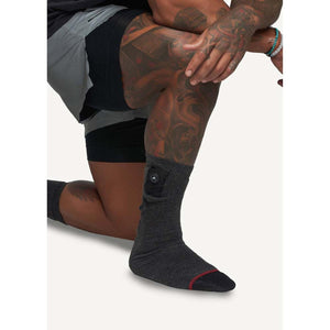 FNDN heated grey crew sock with battery pocket on a person kneeling