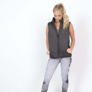 Woman wearing a black FNDN quilted vest and grey patterned leggings