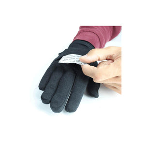 Hand inserting a small heat pack into a black glove