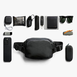 Bellroy sling bag surrounded by everyday carry items including phone, wallet, sunglasses, and accessories