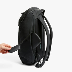 Hand holding a Bellroy backpack key clip attached to a black bag