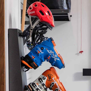 GearDryer wall rack holding a red POC helmet and two pairs of ski boots