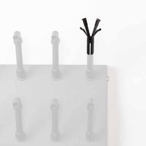 Black plastic boot dryer attachment on a white wall mounted rack