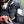 Motorcyclist wearing black Acerbis jacket and helmet holding a red smartphone