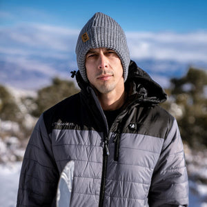 Man wearing a grey ActionHeat beanie and a grey and black insulated jacket outdoors in winter
