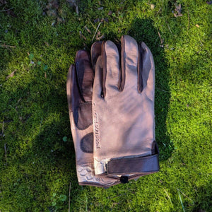 Glacier Glove tan and brown leather gloves on green moss