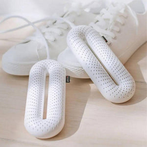 Glovii white electric shoe dryer with perforated surface in front of white sneakers