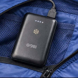 Black Gobi power bank with snowflake logo and LED indicators inside a blue jacket pocket