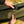 Hand connecting a power bank to the integrated heating control button on a green camping hammock