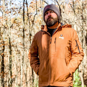 Man wearing a Gobi Heat jacket and beanie in a forest
