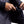 Person placing a black power bank into the interior pocket of a dark grey jacket