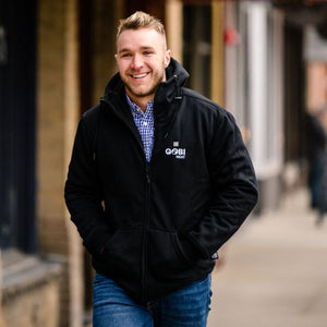 Man wearing a black Gobi Heat zip up hoodie over a blue gingham shirt