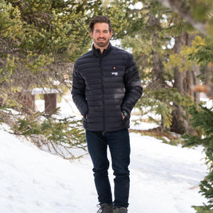 Man wearing a black Gobi Heat puffer jacket standing in a snowy forest