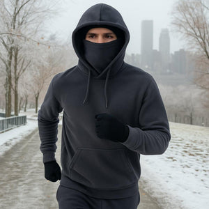 Person wearing a Gobi Heat charcoal fleece hoodie and face mask running on a snowy path