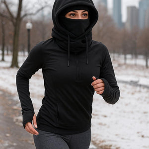 Person wearing a black Gobi Heat hooded quarter zip running in a snowy park