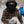 Child wearing a Gobi Heat brown plaid shirt and black face mask holding a snowball outdoors in winter