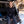Woman wearing a black Gobi Heat long sleeve shirt sitting in the back of a car with skis